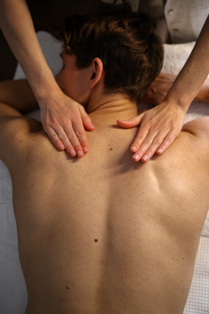 programs-01 Man receiving relaxing massage therapy on upper back at spa.