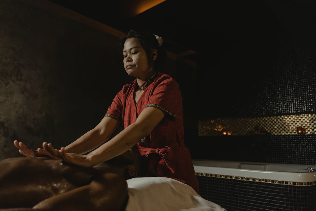 hero-gallery-04 Professional masseuse performing relaxing spa massage in dimly lit room.