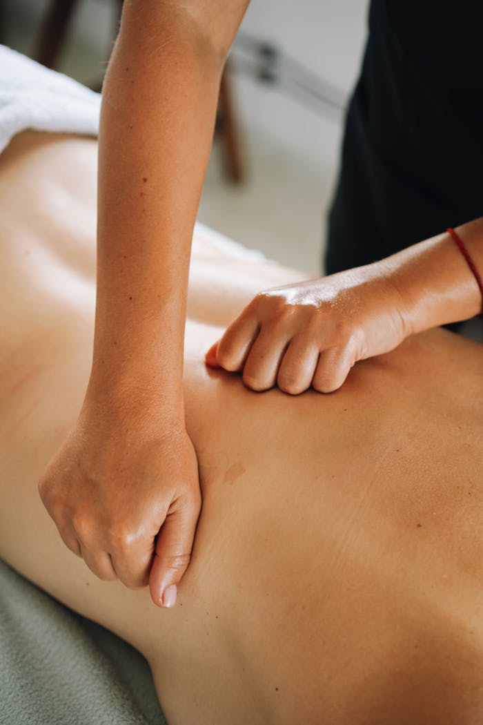 programs-03 Close-up of a relaxing therapeutic massage focusing on back muscles in a tranquil spa environment.